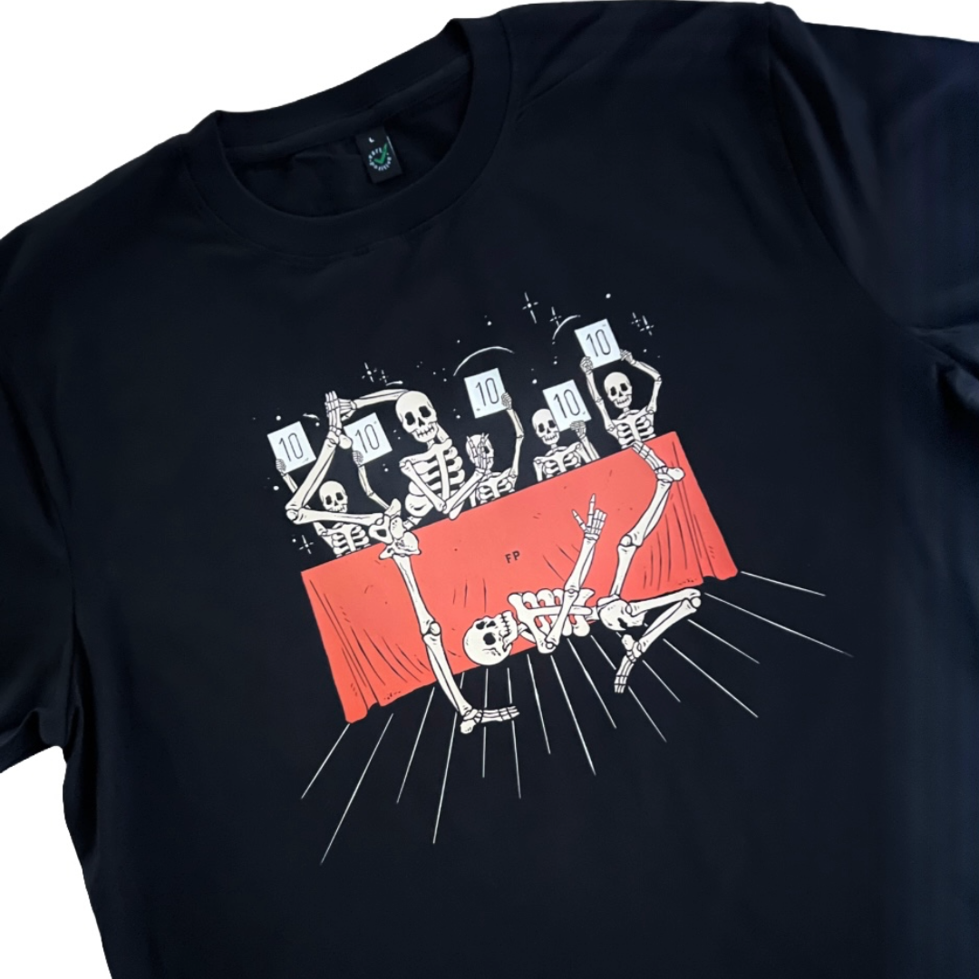 closeup of a black unisex t-shirt with two skeletons doing voguing poses from New York ballroom scene. there is a judges table behind them where the skeleton judges are scoring them 10