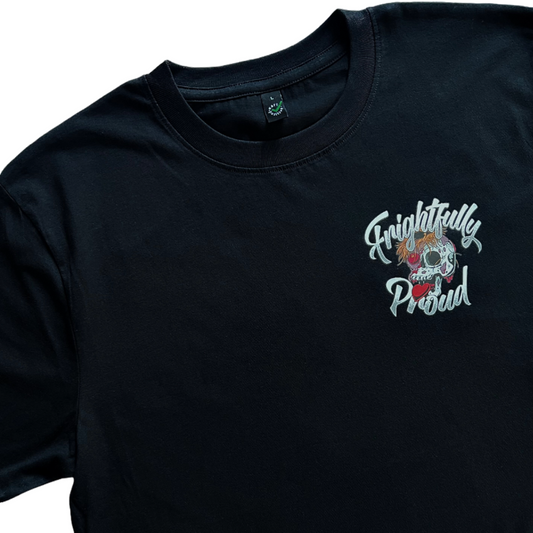 closeup of the front of the black unisex t-shirt showing a pocket sized design of a decaying skull with a love heart coming from it's mouth. text saying Frightfully Proud is around it