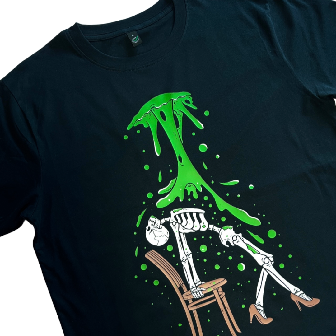 closeup of a black unisex t-shirt with a skeleton doing a sexy pose on a chair whilst toxic waste falls on them