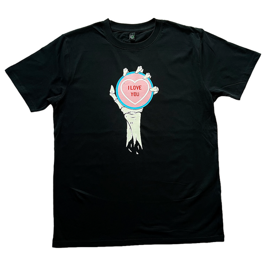 black unisex t-shirt of a skeleton hand and forearm holding an oversized love heart candy that reads I Love You on it. the colours of the candy are in the colours of the transgender flag